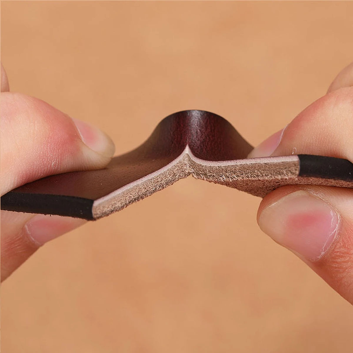 Full-grain leather of the Vanefield belt bent to show its flexibility