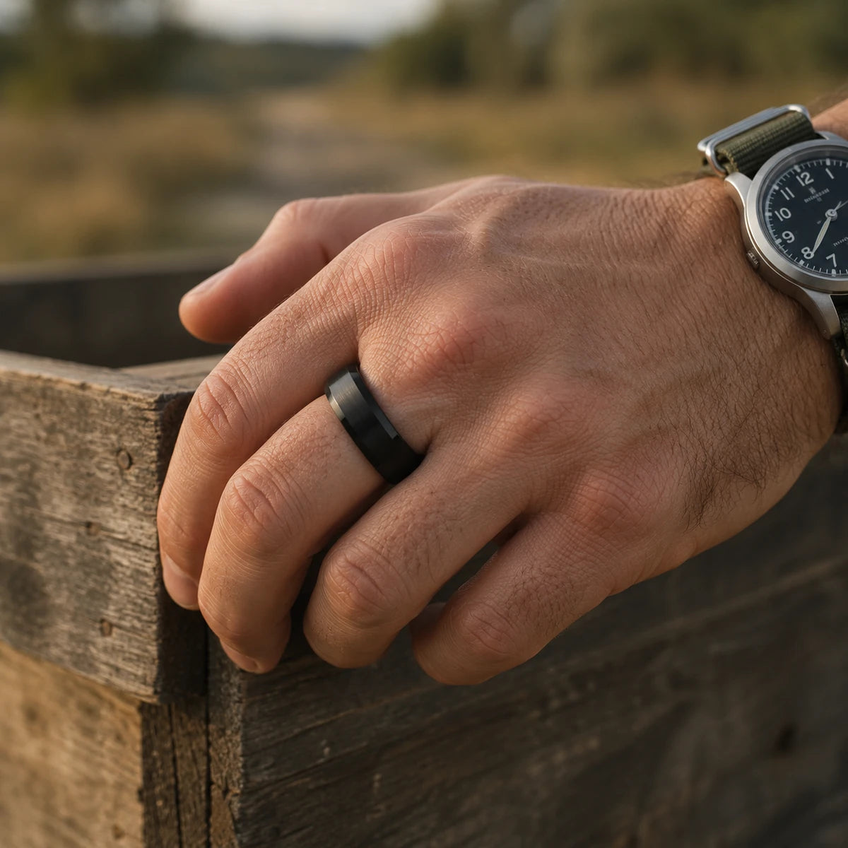 Man's hand on a wooden crate wearing the Vanefield Valor Ring in gunmetal