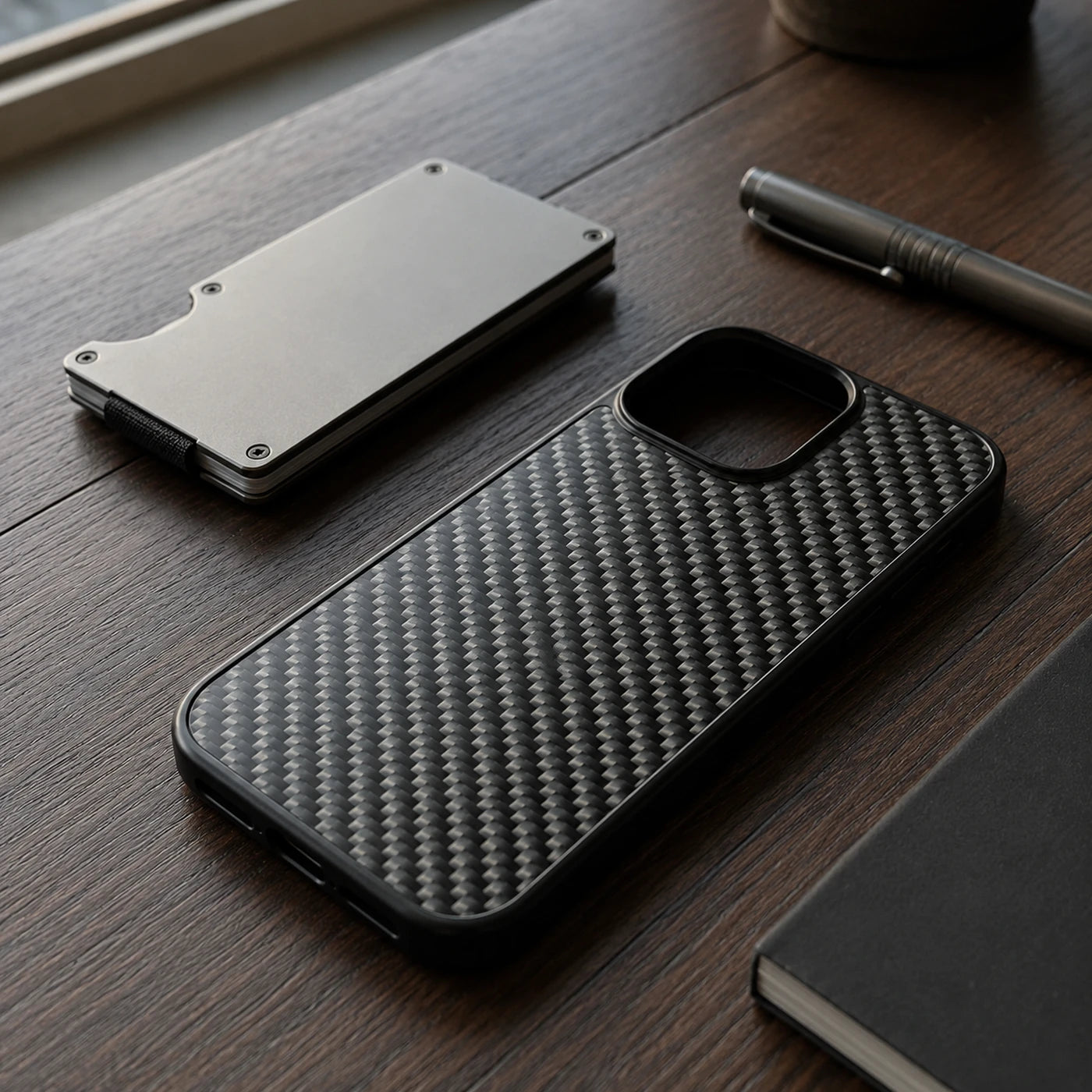 Vanefield CarbonArmor Case on a wooden desk with a cardholder and a pen
